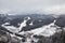 Panorama of the prepared ski slope bukovel among spruce forest on a background of mountain ranges and sky on ski resort in Carpath