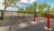 Panorama Private gate at a secured property with red traffic poles on the paved gray road