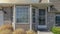 Panorama Puffy clouds at sunset Entrance of a house with stone veneer and vinyl wood siding