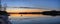 Panorama of a quiet, picturesque lake after sunset