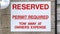 Panorama Reserved sign and downspout against wall of building and corrugated garage door