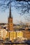 Panorama with Riddarholm Church and colorful houses around on sunny winter day, view from the hilltop.