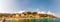 Panorama of rocky marina, clear water of Ligurian Sea, sea ships, beach full of people, waterfront buildings in Monterosso Al Mare