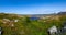 Panorama of the rocky ocean coast on Leka island overlooking the mountains and Heilhornet peak on the horizon under blue clear