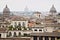 Panorama of Rome`s rooftops with three church domes. Photograph