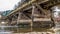 Panorama Rustic wooden bridge over a rocky stream with shiny water