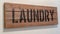 Panorama Rustic wooden stencilled Laundry sign on blank white wall