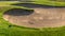 Panorama Sand bunker of a golf course and view of bright sun and puffy clouds in the sky