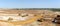 Panorama of the sand quarry. Extraction of sand in the quarry. Backhoe loading sand into dump trucks.