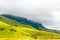 panorama scenic landscape of South Africa Drakensberg, green plane and mountains in dense clouds with rocks and bushes