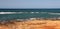 Panorama of the seashore, rocky shore in the foreground of bright colors