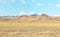 Panorama of the semi-desert with withered grass, hills and mountains in the background