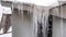 Panorama Sharp spiked icicles on roof with snow against snowy hill landscape in winter