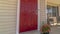 Panorama Shiny red wooden front door of a home with wicker chairs on the sunlit porch