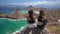 Panorama shot of girls sitting on the top of hill and enjoying the scenery of ocean and islands