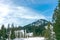 Panorama of ski resort, slope, people on the lift, skiers on the track among the pines.