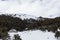 Panorama of ski resort, slope, people on the ski lift, skiers on the piste among white snow pine trees. Winter season