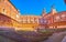 Panorama of small cloister with garden and huge Cathedral of Certosa di Pavia monastery, Italy