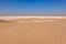 Panorama of small desert dunes with red sand on the limestone horizon. Oman.