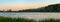 Panorama of a small lake at dusk