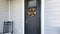 Panorama Small porch of a traditional house with black front door with wreath and black rocking chair