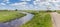 Panorama of a small river going through the flat dutch landscape in Groningen