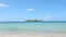 Panorama at small white waves ran from blue ocean to golden sandy beach