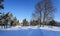 Panorama of a snow-covered city park with long shadows on a sunny morning in Riga