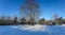 Panorama of a snow-covered city park with long shadows on a sunny morning in Riga, Latvia.