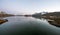 Panorama of Snow covered mountains and powerful streams in the ocean during blue hour in Flakstad, Lofoten in Norway.