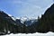 Panorama of snow and trees covered Alps from tourist path heading directly towards to Murg lakes