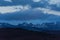 Panorama of snowy mountains at sunset. Majestic clouds over the mountains