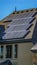 Panorama Solar panels on the dark gray roof with blue sky background on a sunny day