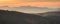 Panorama Sowie Mountains, orange sunset over the mountain valley shrouded in fog