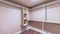 Panorama Spacious walk in closet of new home with metal rods shelves and wooden floor