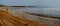 Panorama of the spring beach on the Volga river and the beginning of the ice drift in sunny weather.