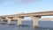 Panorama Stringer bridge supported by abutments ovelooking lake land and cloudy sky