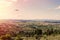 Panorama of the suburbs of the Greek city of Athens with landing plane at sunset