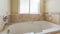 Panorama Sun flare Alcove bathtub in a bathroom with matte marble tiles surround