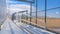 Panorama Sunlit bleachers overlooking a vast sports field on the other side of the fence