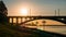 Panorama of sunset over river, modern bridge and city embankment, beautiful urban evening landscape