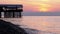 Panorama of the Sunset over the Sea next to the Silhouette of the Pier.