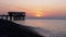 Panorama of the Sunset over the Sea next to the Silhouette of the Pier.