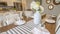 Panorama Table setting inside a dining room with brown table and white chairs