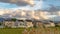 Panorama Tall brown grasses with stylish homes and snow capped mountain in the background