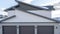 Panorama Three door garage of a lovely home against snowy slope and cloudy blue sky