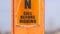 Panorama A torn Caution sign on a bright orange post against a blurry background