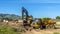 Panorama Truck and excavator at a construction site with blue sky overhead on a sunny day