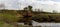 Panorama of the twisting abrupt coast of the small river with power lines