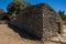 Panorama of typical hut made of stone with walled fence and sunny blue sky, in the Village of Bories, near Gordes.